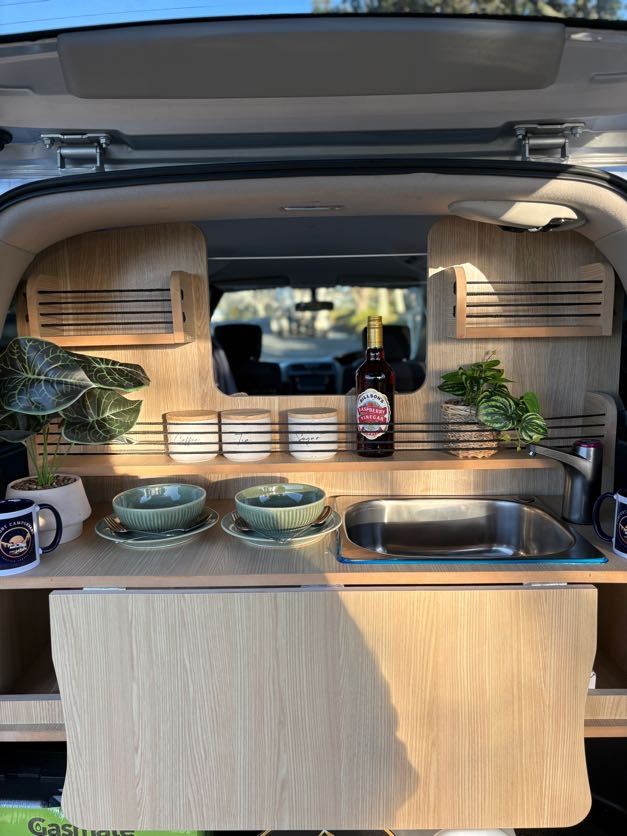 Rear kitchen with sink, fold-down worktop and storage, seen through the open tailgate