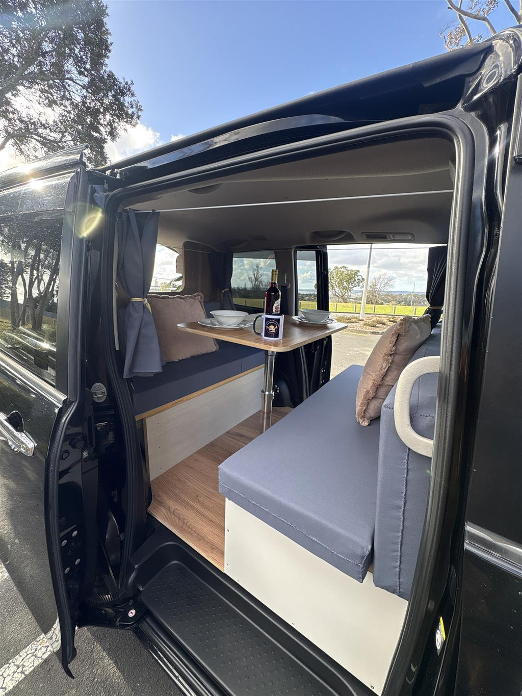 Nissan Serena campervan with sliding door open showing lounge and table